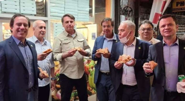 Jair Bolsonaro come pizza na rua em Nova York, pois não pode entrar em restaurantes