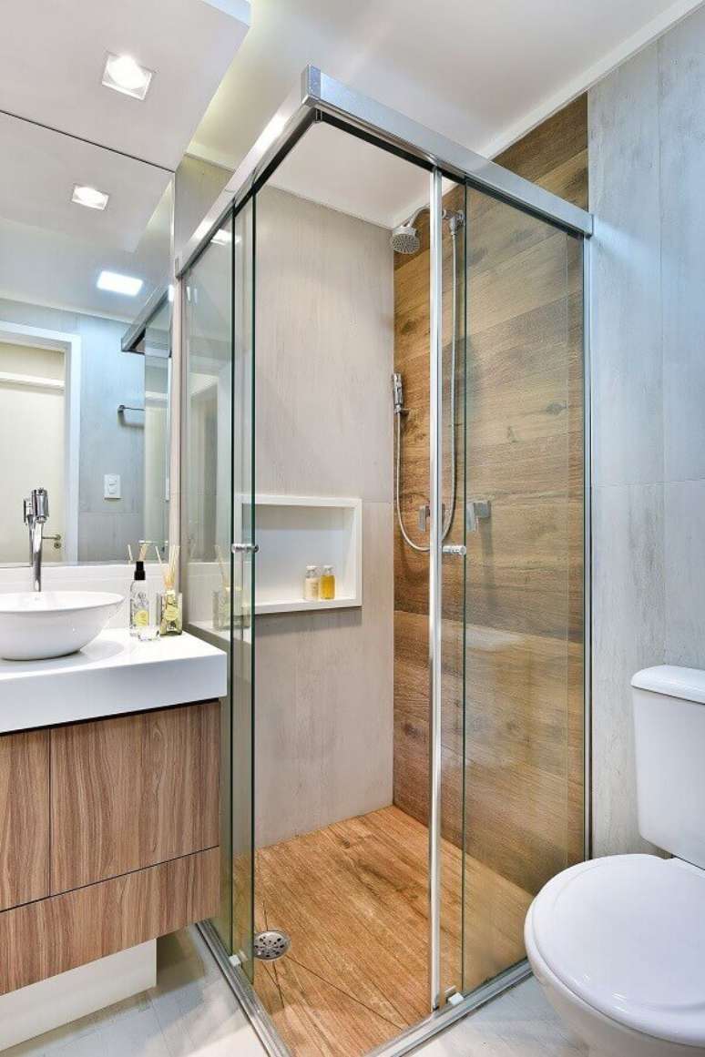 45. Decoração simples para banheiro com piso de madeira no box e gabinete pequeno suspenso – Foto: Tetriz Arquitetura