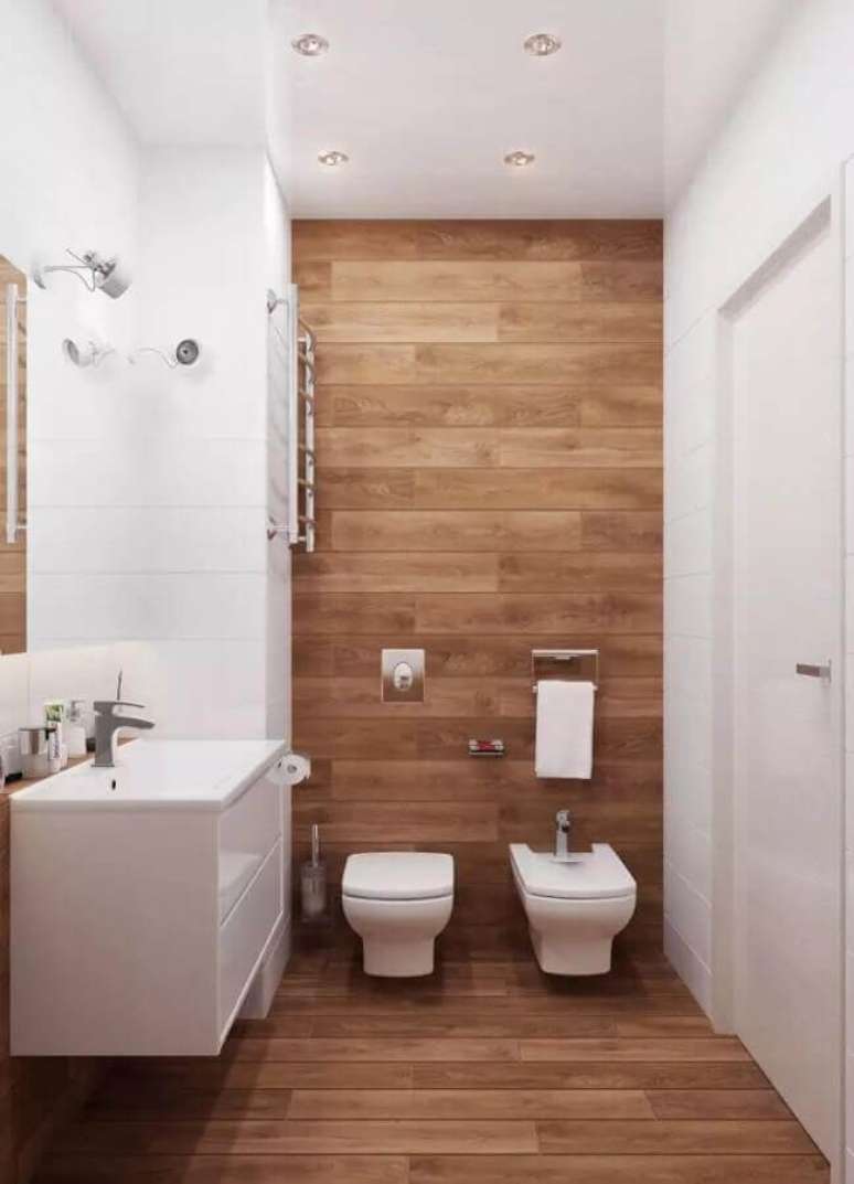 27. Decoração de banheiro com piso de madeira e gabinete branco pequeno – Foto: Valeru Anka