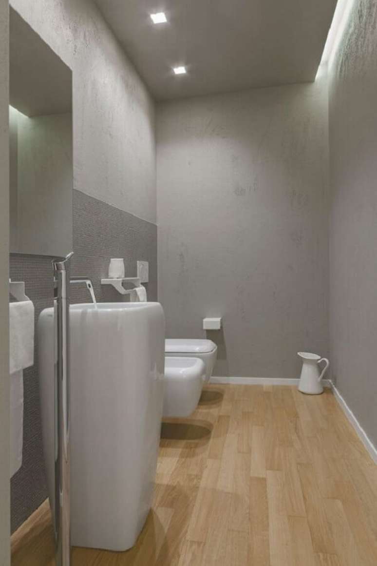43. Decoração moderna para banheiro com piso de madeira e parede de cinza – Foto: HomeDSGN
