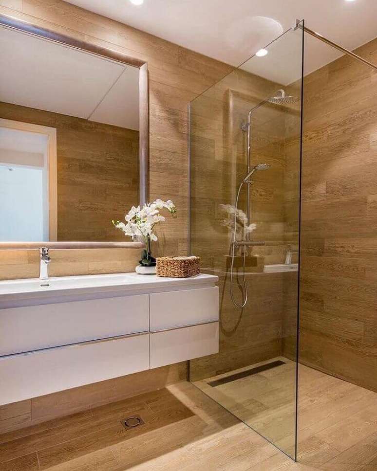 49. Gabinete branco suspenso para decoração de banheiro com piso de madeira – Foto: Home Fashion Trend