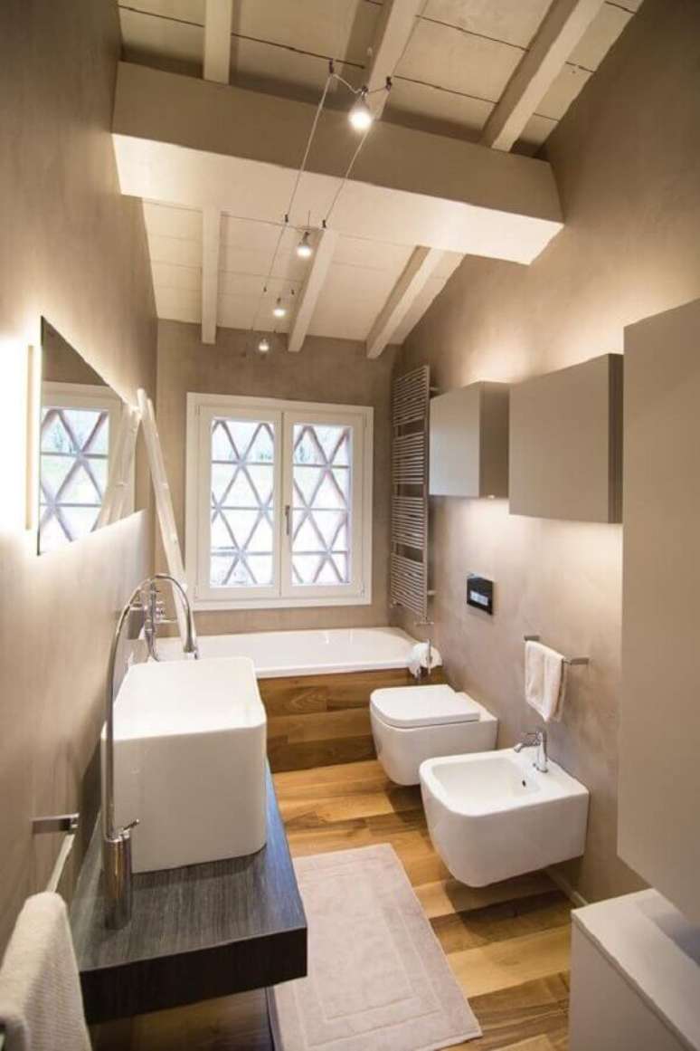30. Decoração de banheiro pequeno com piso de madeira e banheira – Foto: The Architect’s Diary