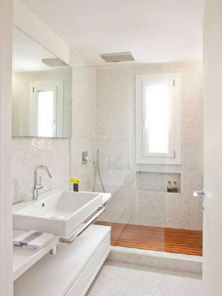 23. Decoração clean para banheiro com piso de madeira e pastilhas brancas – Foto: Decor Fácil