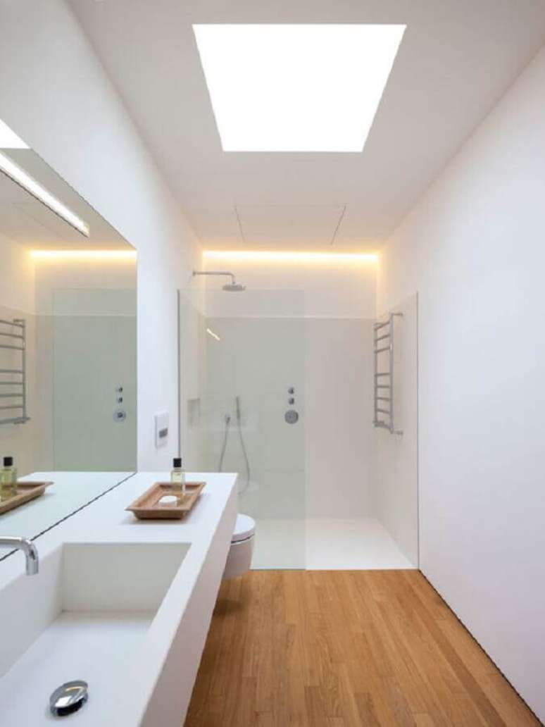 32. Decoração minimalista com bancada planejada para banheiro com piso de madeira – Foto: Habitissimo
