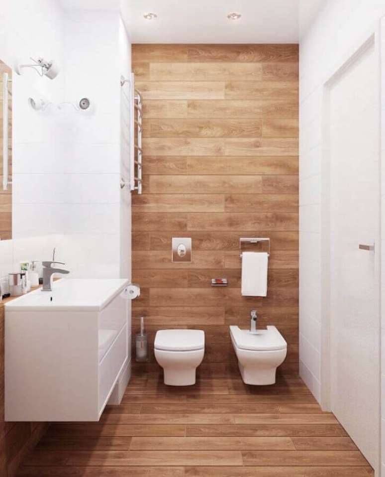 21. Decoração clean para banheiro com piso de madeira e gabinete branco pequeno – Foto: Decor Fácil