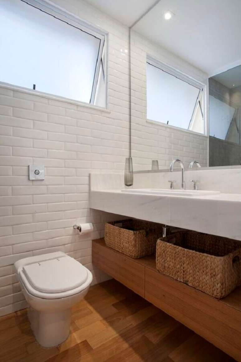14. Banheiro com piso de madeira decorado com metro white e bancada de mármore – Foto: Escritorio InTown