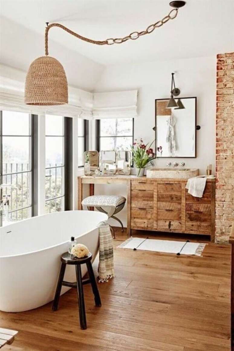 51. Lustre rústico para decoração de banheiro com piso de madeira e banheira de imersão – Foto: Clem Around The Corner