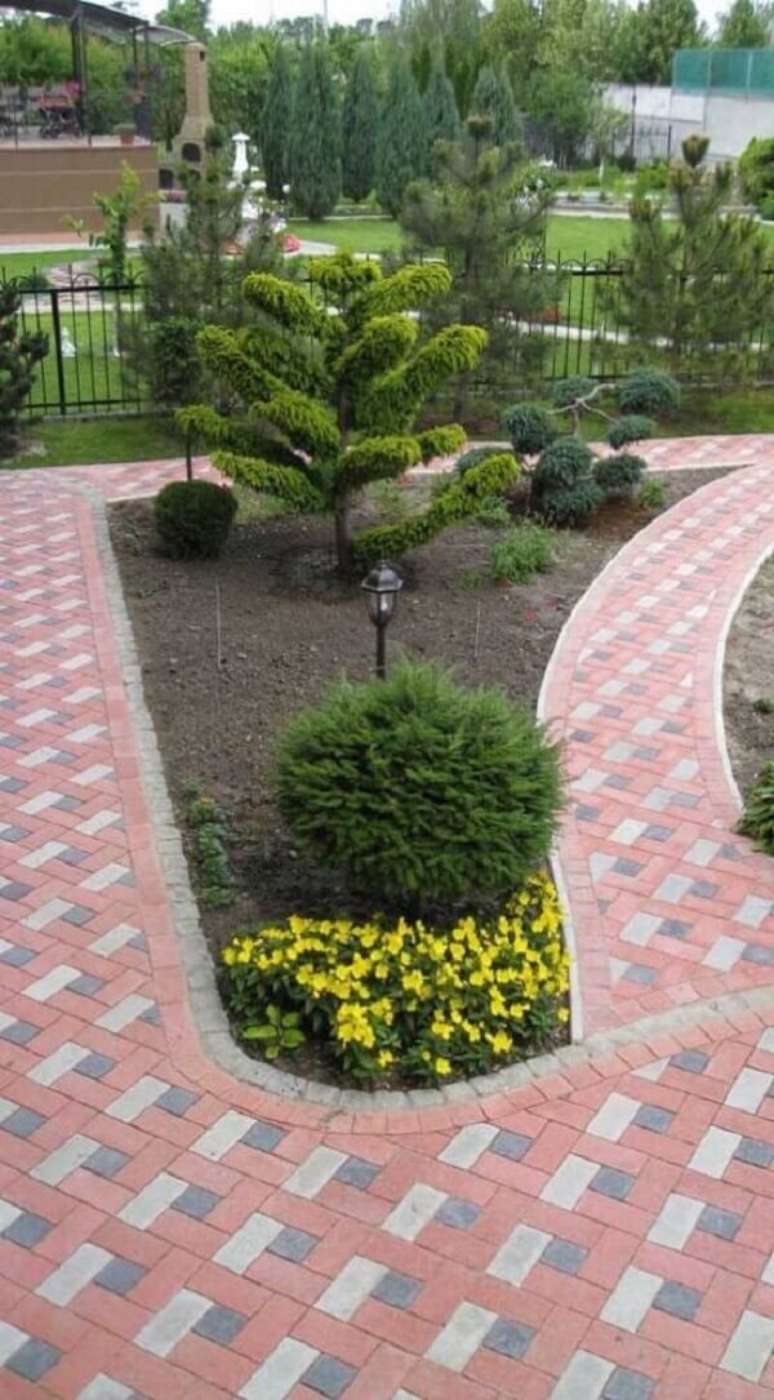 24. O piso intertravado vermelho forma lindos caminhos pelo jardim da resid&ecirc;ncias. Fonte: The Ofy