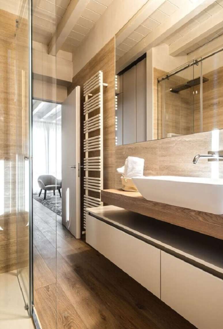 36. Decoração moderna com gabinete planejado para banheiro com piso de madeira – Foto: Decor Fácil