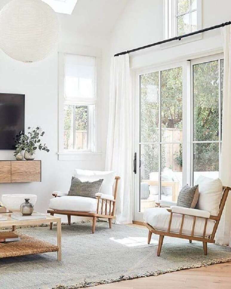 6. Sala de TV decorada com lustre redondo e poltrona branca com madeira &ndash; Foto: Studio McGee