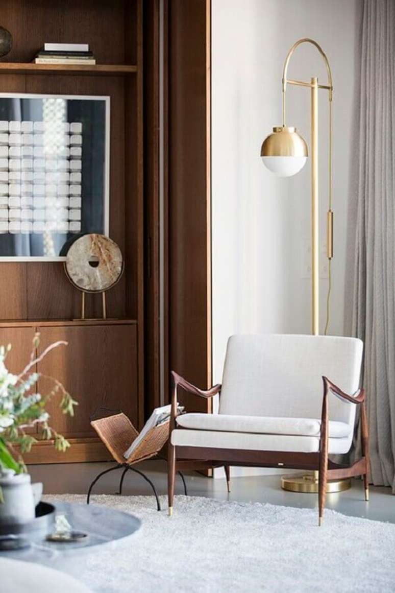 30. Poltrona decorativa branca para decora&ccedil;&atilde;o de sala com lumin&aacute;ria de piso e estante de madeira &ndash; Foto: Behance