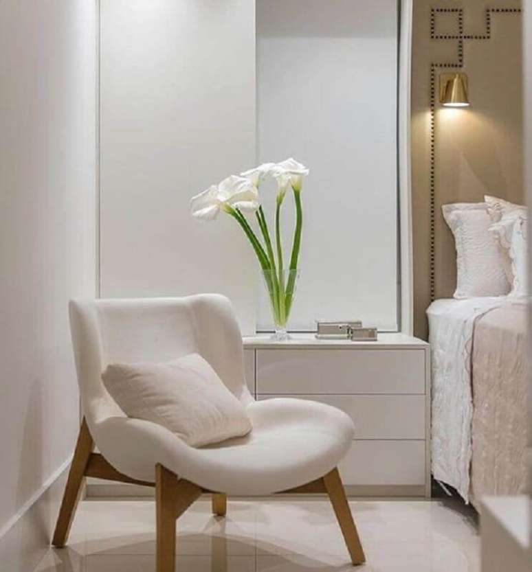 10. Cores neutras para quarto decorado com poltrona branca e luminária de parede – Foto: Decor Fácil