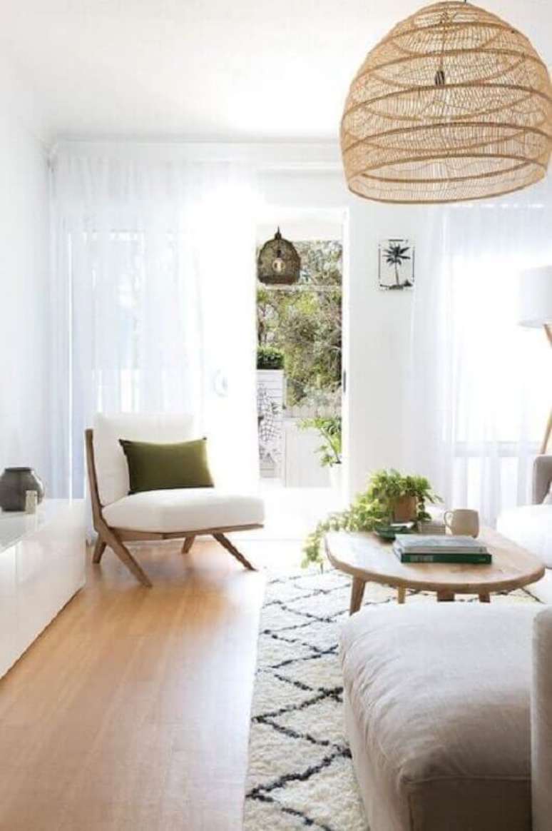 52. Poltrona branca para sala decorada em cores claras com lustre rustico – Foto: Apartment Therapy