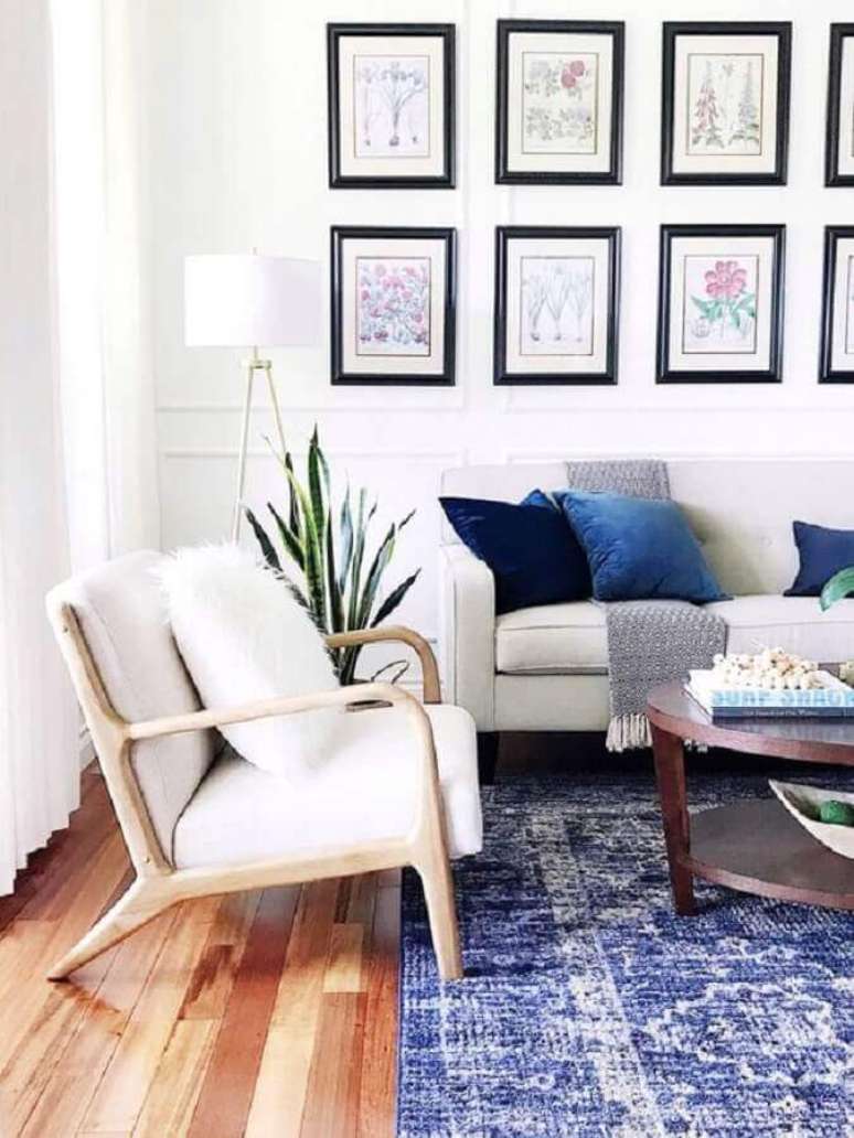 59. Sofá e poltrona branca para sala decorada com mural de quadros e almofadas azuis – Foto: Essential Home