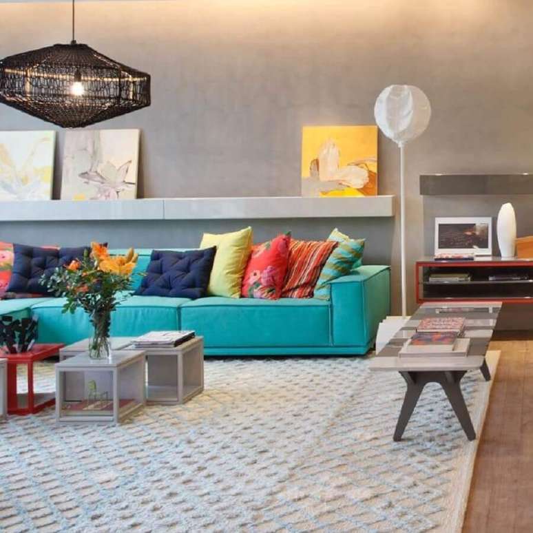 12. Almofadas coloridas para sofá cor ciano em sala moderna decorada com parede de cimento queimado – Foto: Paula Neder Arquitetura