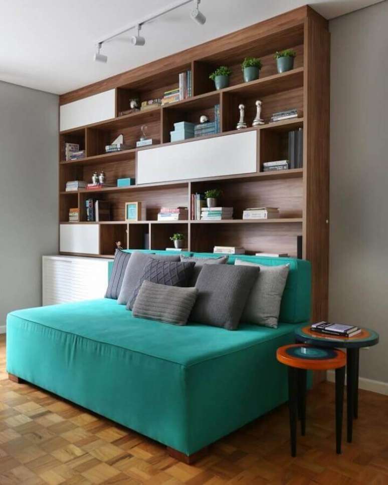 61. Sofá sem braço cor ciano para decoração de sala com estante de madeira – Foto: GF Projetos