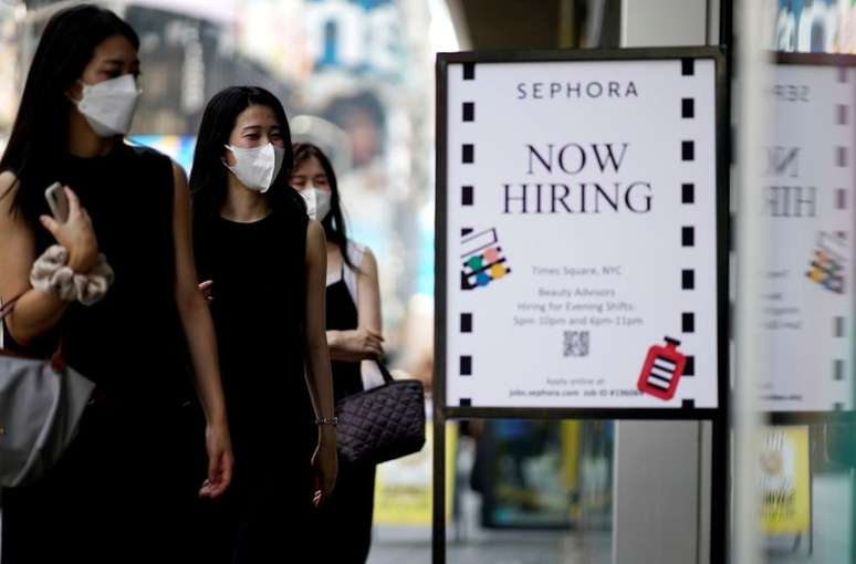 Placa anunciando vagas de emprego é vista enquanto as pessoas entram em loja na cidade de Nova York, Nova York, EUA, 6 de agosto de 2021. REUTERS/Eduardo Munoz