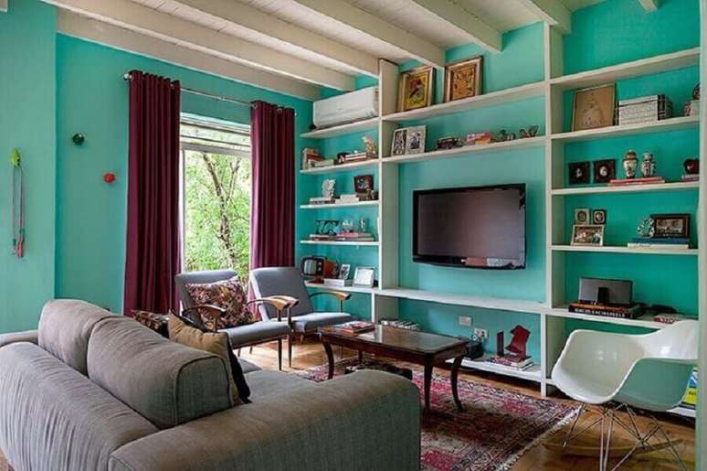 8. Parede cor ciano para sala de TV decorada com sofá cinza – Foto: Julia Ribeiro Fotografia