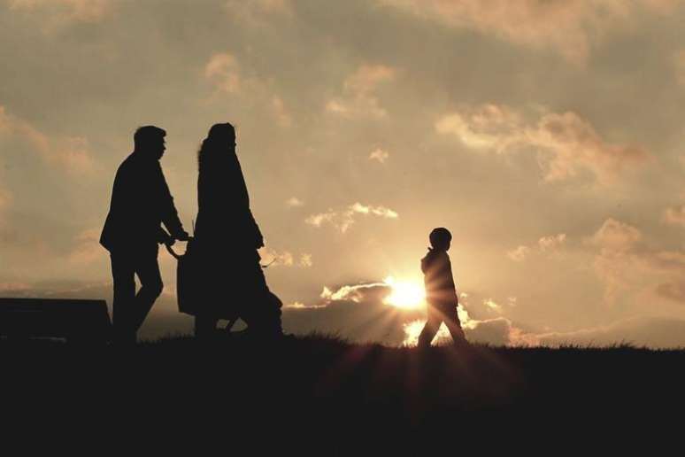 Família unida em fé caminhando à tarde em colina - Reprodução/Canva.com