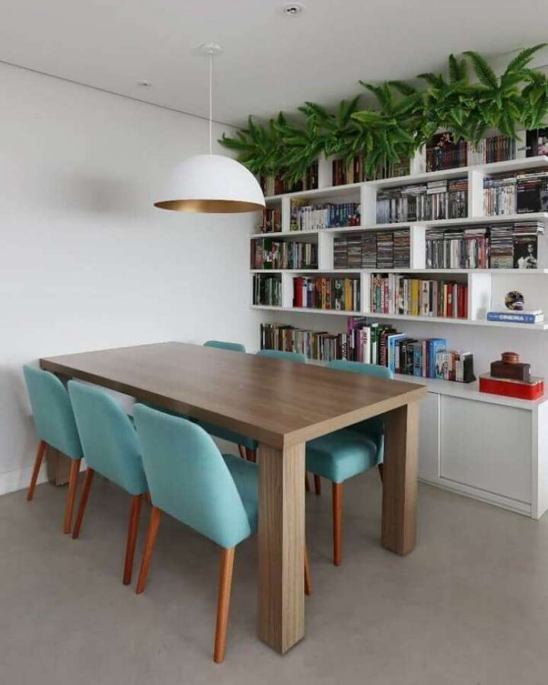 2. Cadeira cor azul ciano para decoração de sala de jantar com estante branca para livros – Foto: GF Projetos