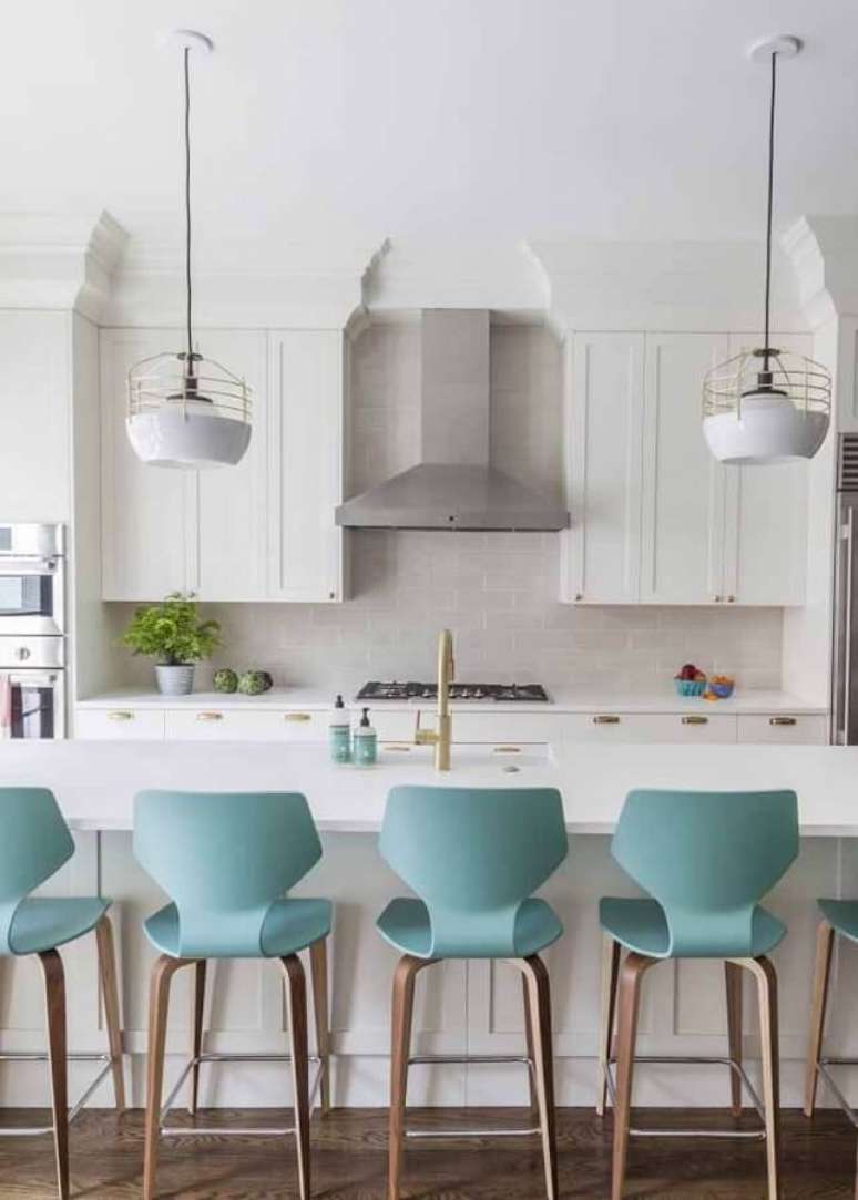 9. Cozinha com ilha branca decorada com banqueta cor ciano – Foto: Apartment Therapy