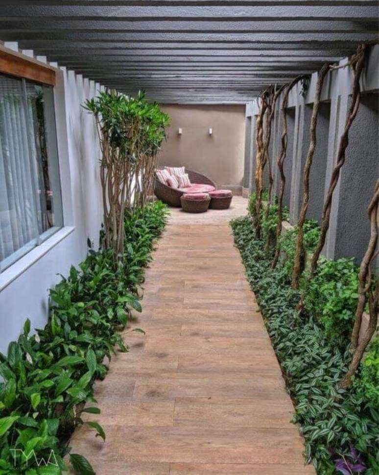 42. Pergolado de concerto e chaise decoram o corredor do im&oacute;vel. Fonte: TYWA