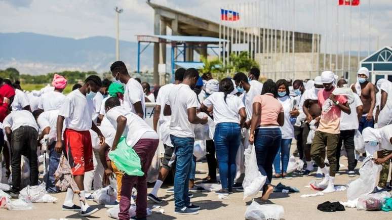 Pessoas deportadas para Porto Príncipe foram forçadas a buscar seus pertences no chão após chegarem ao Haiti