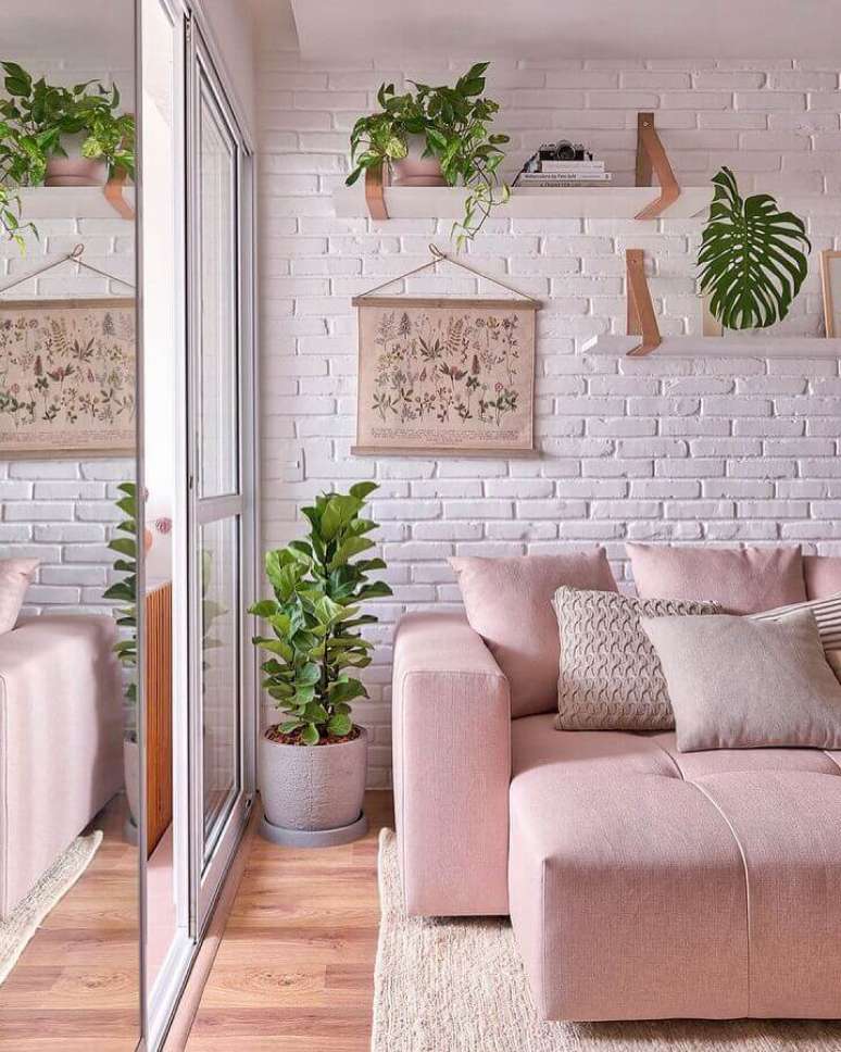 37. Sofá rosa para decoração de sala com plantas e parede tijolinho branco – Foto: Decor Fácil