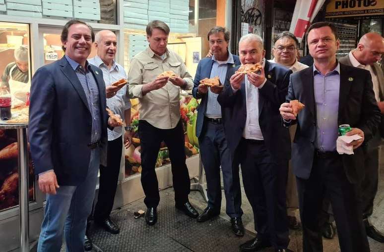 Acompanhado de parte da comitiva brasileira, Bolsonaro come pizza na calçada em Nova York.