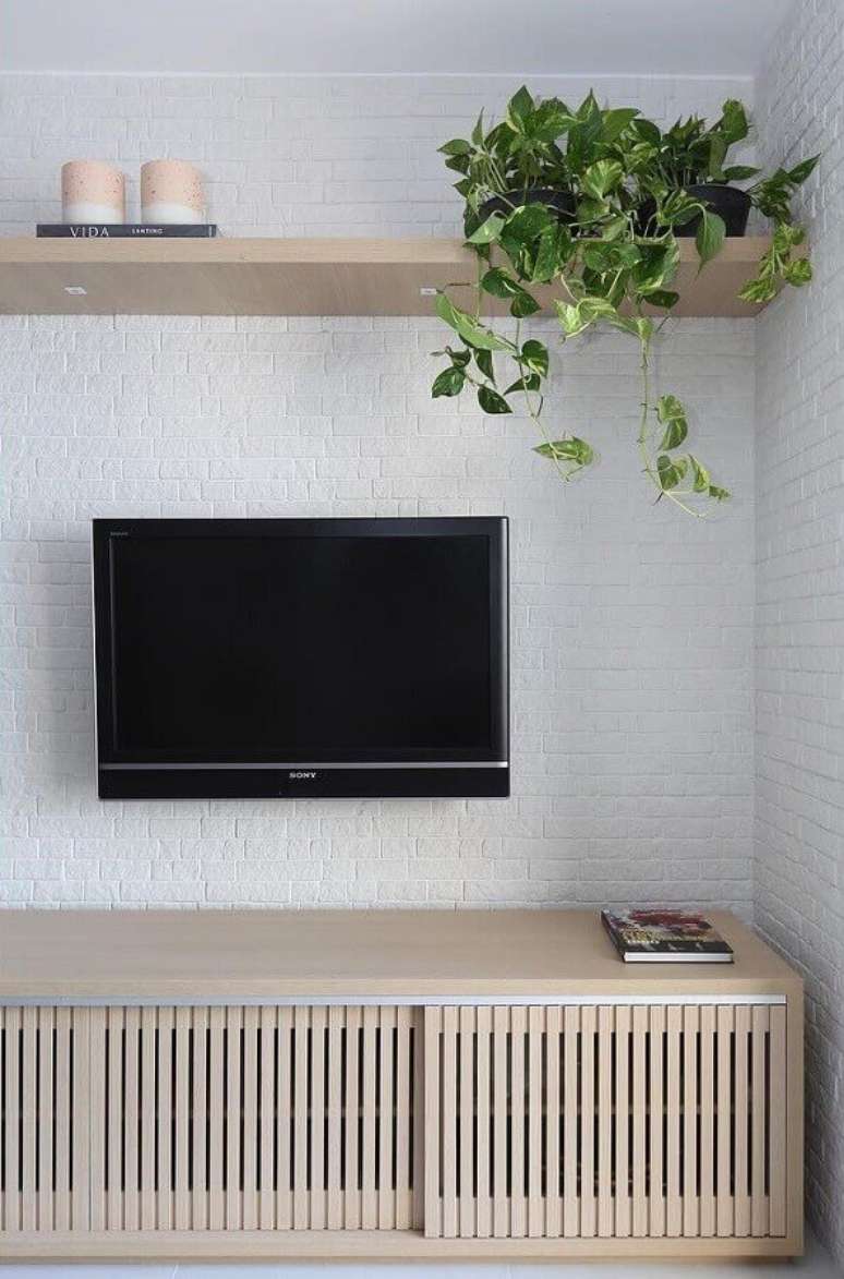 30. Parede tijolinho branco para decoração de sala com plantas e rack de madeira – Foto: Bianchi e Lima Arquitetura
