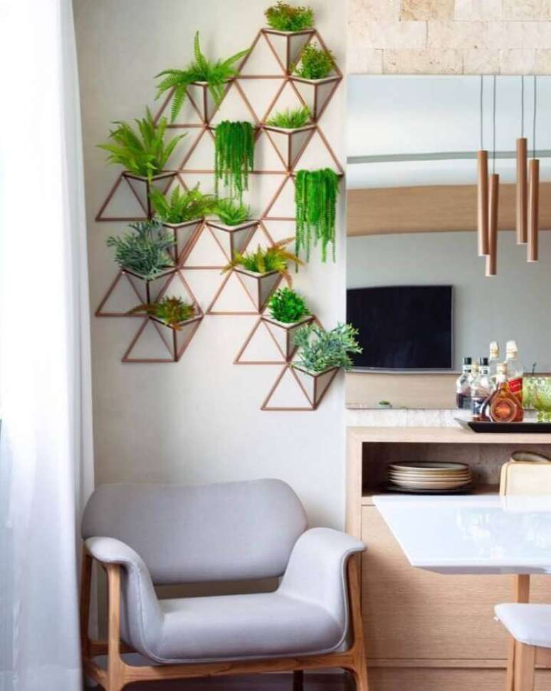 18. Decoração de sala com plantas naturais na parede e poltrona cinza – Foto: Tamiris Ribas Arquitetura