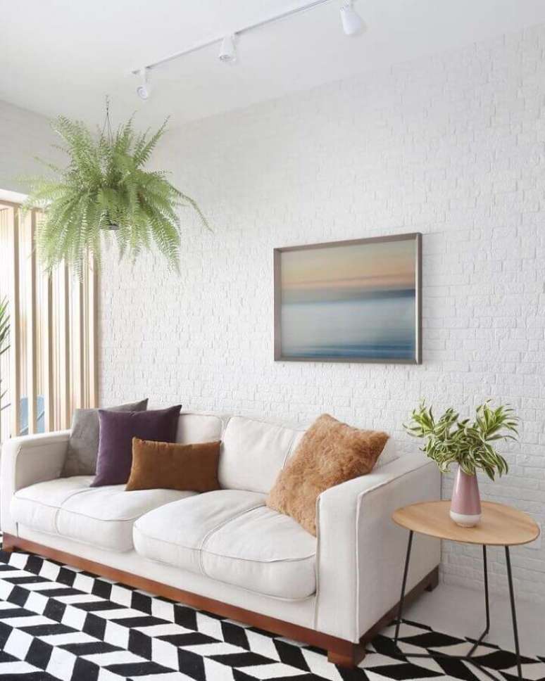 8. Cores claras para decoração de sala com plantas naturais e tapete preto e branco – Foto: Bianchi e Lima Arquitetura