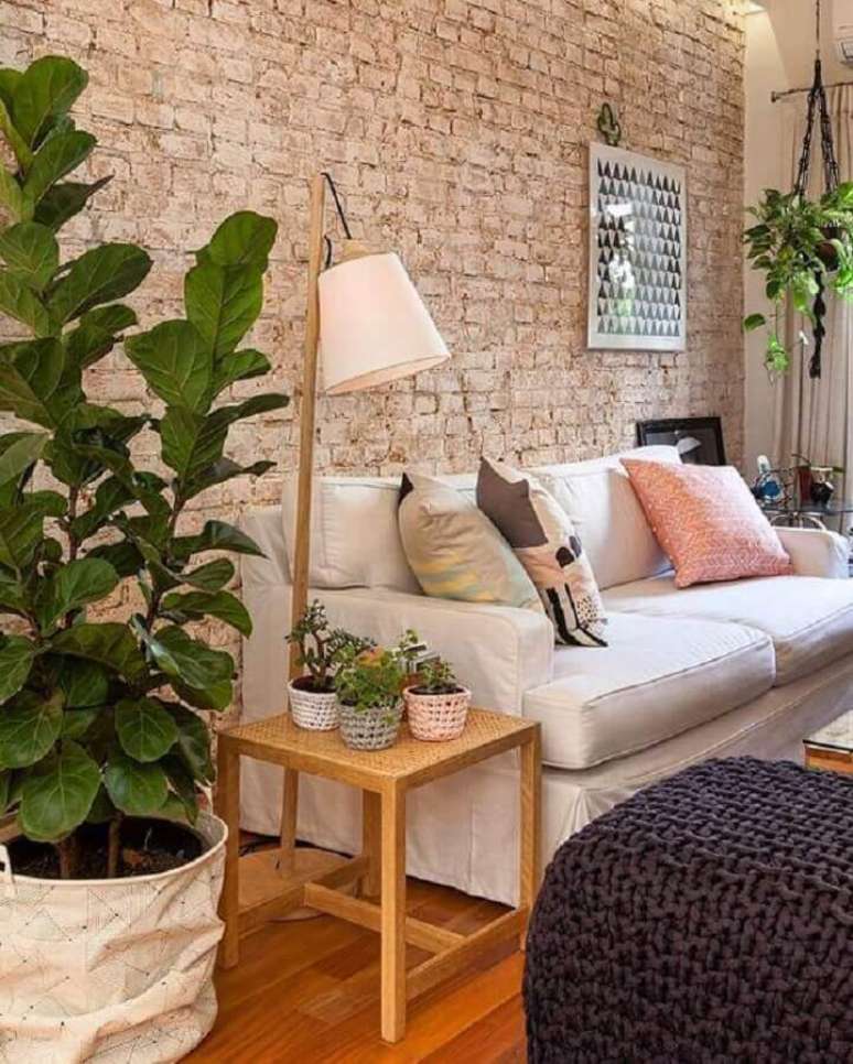 27. Parede de tijolinho rustica para decoração de sala com plantas e sofa branco – Foto: Studio Floral Dora Santoro