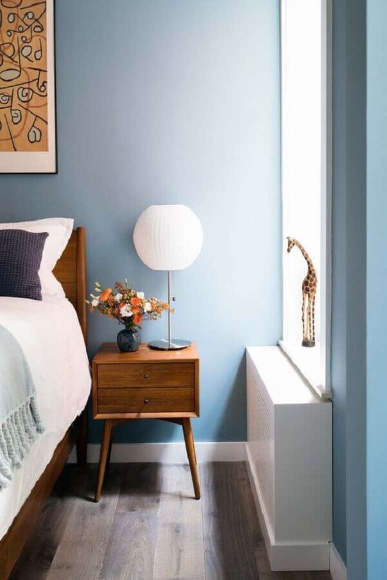 50. Quarto azul decorado com móveis de madeira e abajur para criado mudo – Foto: Amy Barkow