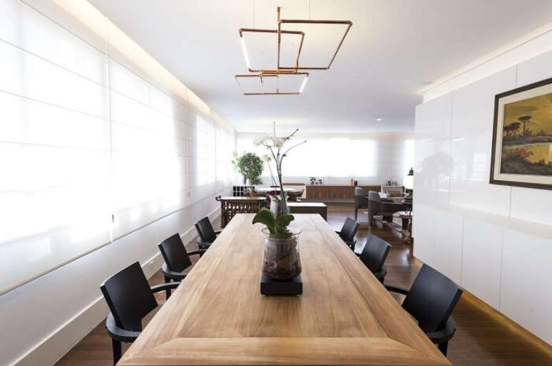 31. Sala de jantar de apartamento de luxo com mesa de madeira e cadeiras em tom preto. Fonte: Carla Cuono Arquitetura e Interiores