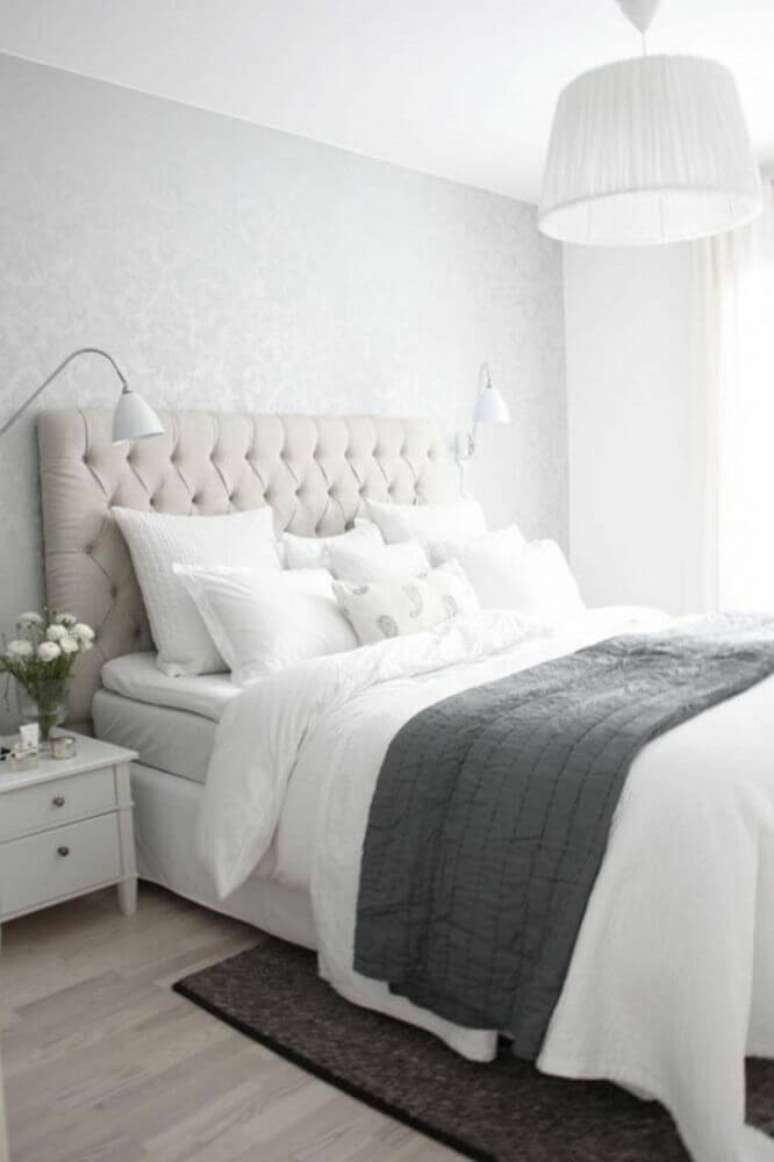 27. Quarto clean decorado com lumin&aacute;ria de parede e cabeceira estofada capiton&ecirc; &ndash; Foto: Archzine