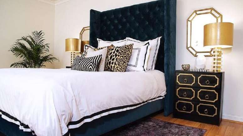 42. Modelo de cabeceira capitonê casal de veludo escuro para quarto de casal sofisticado decorado em tons de preto, branco e dourado – Foto: DecorPad