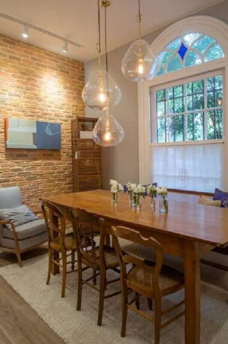 25. Decoração rústica para sala de jantar com luminária de vidro para mesa de madeira – Foto: Casacor Abril
