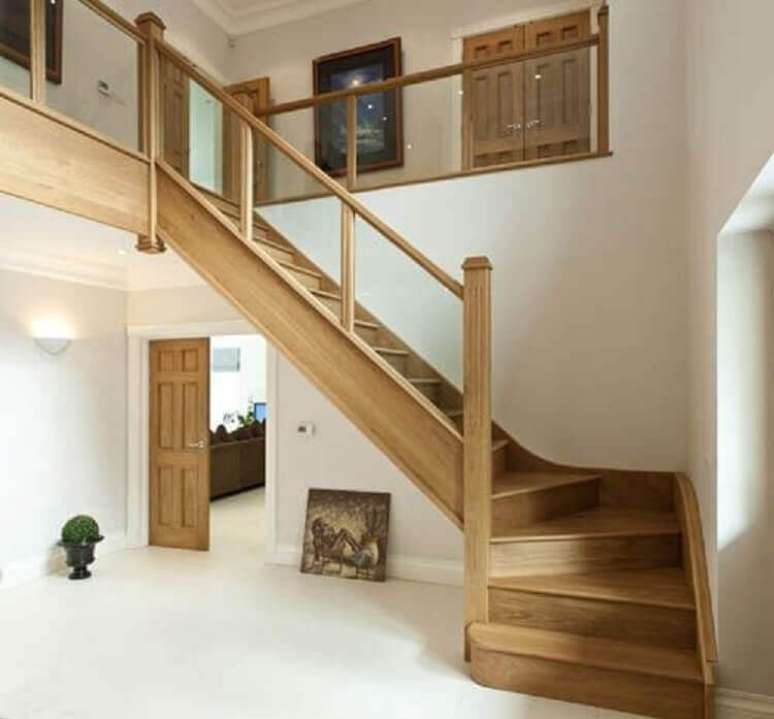 35. Escada de madeira simples com guarda corpo de vidro. Fonte: The Ofy