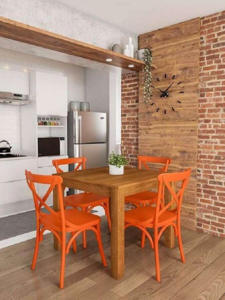 38. Parede tijolinho para sala de jantar rústica decorada com cadeira laranja – Foto: Mobly