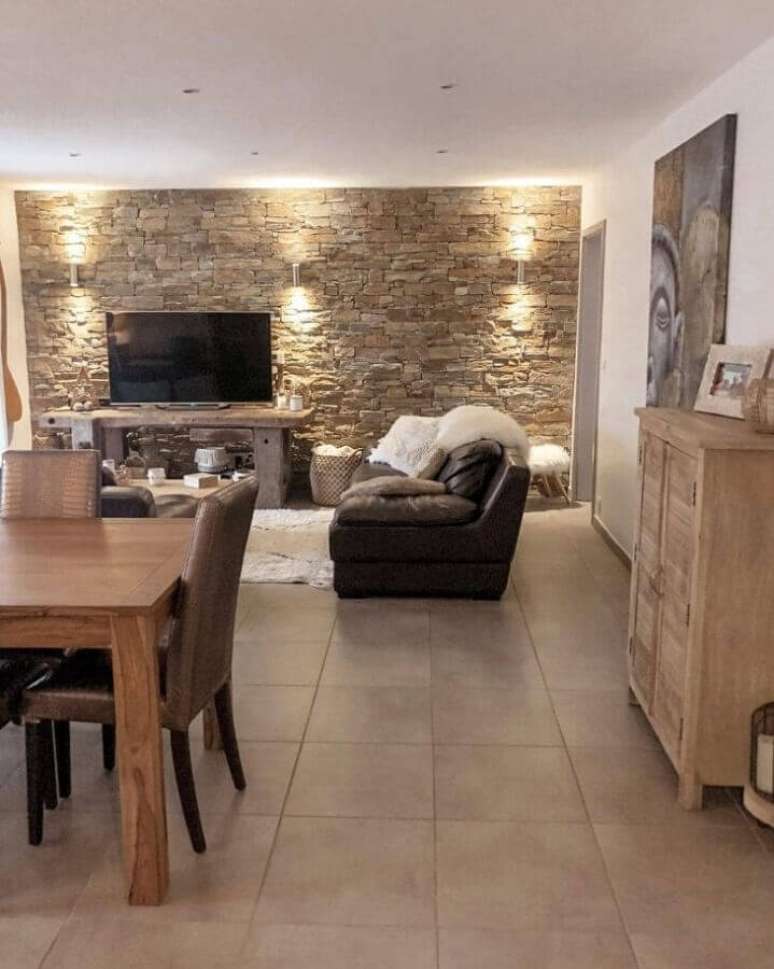 34. Parede de pedra para decora&ccedil;&atilde;o de sala de TV r&uacute;stica integrada com sala de jantar &ndash; Foto: Miss Kiwy