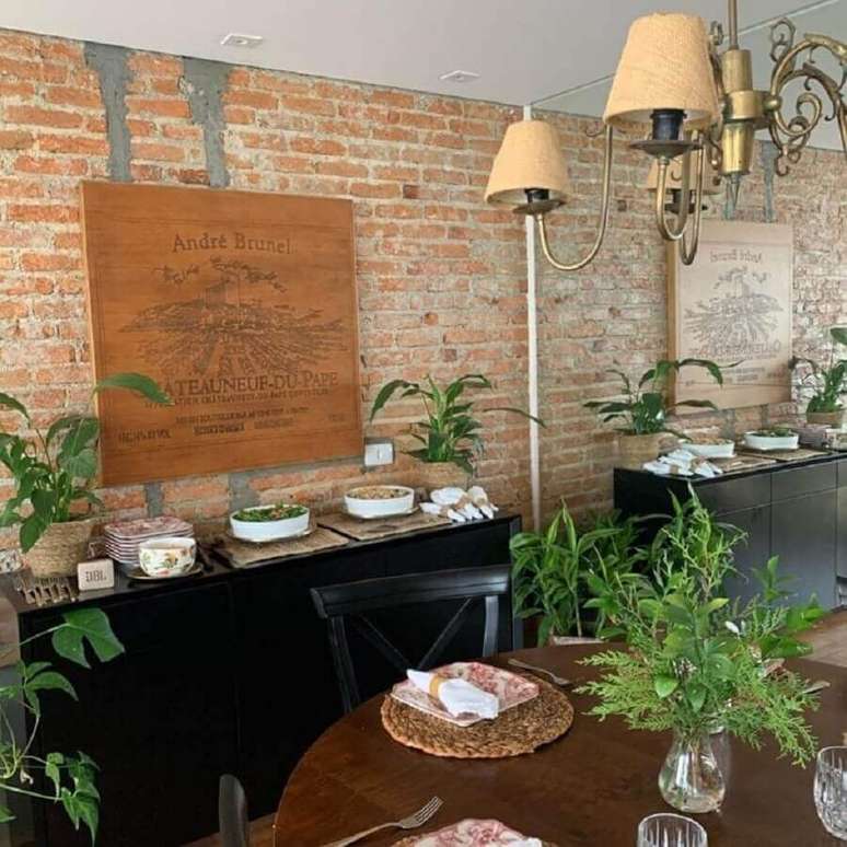 39. Parede tijolinho para sala r&uacute;stica decorada com buffet preto e mesa redonda de madeira &ndash; Foto: Luciana Latorre Interiores