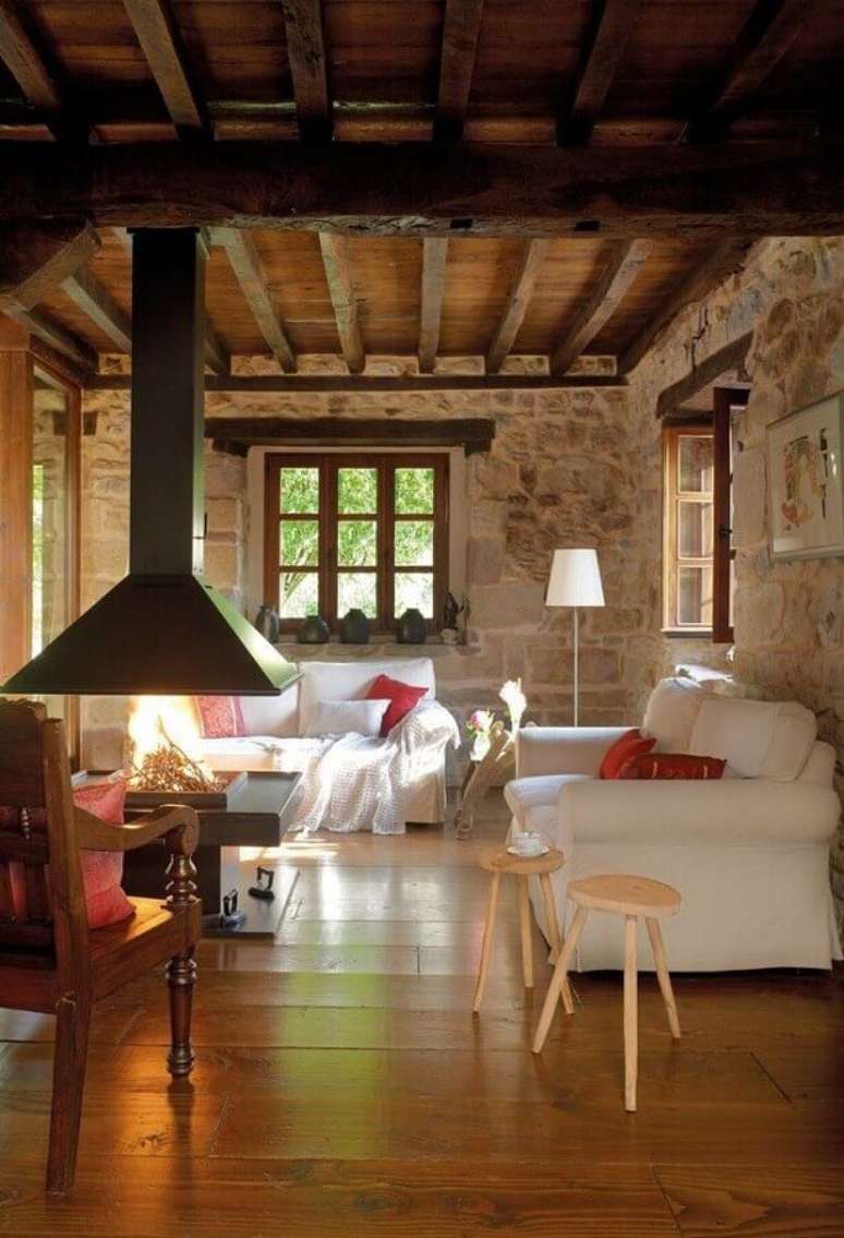 51. Sofá branco para sala rústica com lareira decorada com revestimento de pedra – Foto: Home Fashion Trend