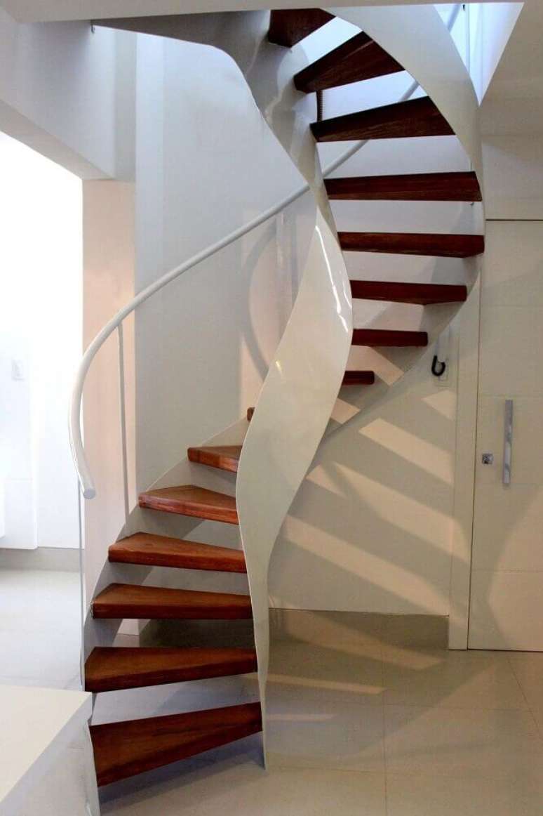 19. Escada caracol de madeira com corrimão branco e design moderno. Fonte: The Ofy
