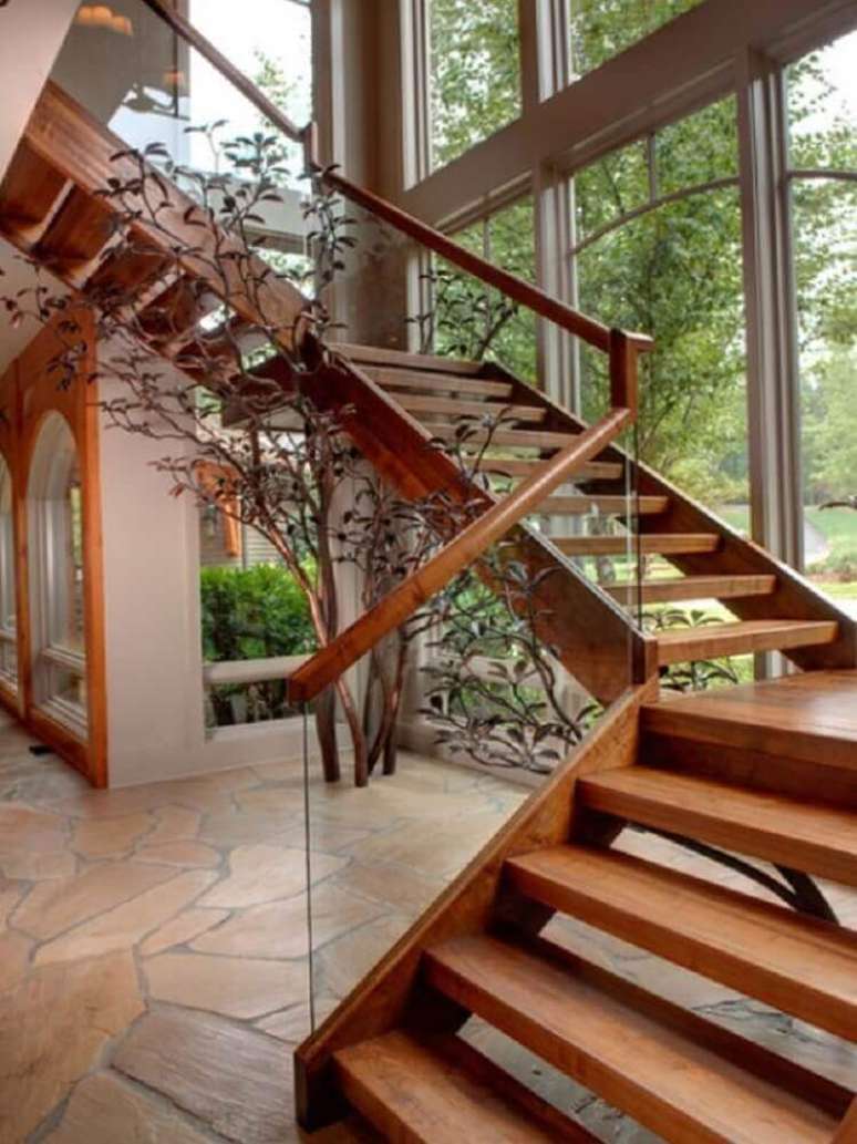 46. Uma das formas de como fazer uma escada de madeira moderna é investindo em um guarda corpo de vidro. Fonte: Haley Woods