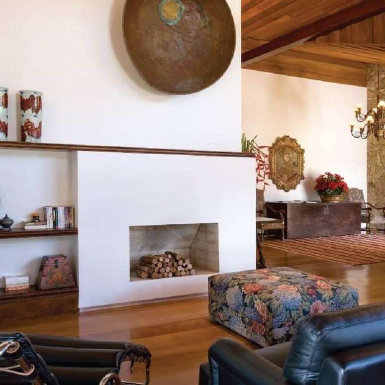 23. Decora&ccedil;&atilde;o r&uacute;stica para sala com lareira a lenha e puff estampado &ndash; Foto: Maria Helena Botrel