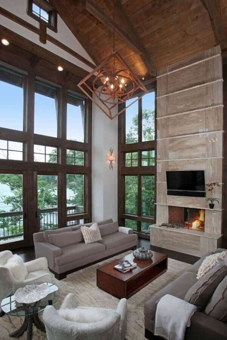 8. Sala de estar r&uacute;stica decorada com lustre moderno e lareira &ndash; Foto: Houzz