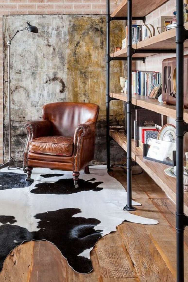 27. Estante de livros para decora&ccedil;&atilde;o de sala r&uacute;stica com poltrona de couro &ndash; Foto: Casa de Valentina