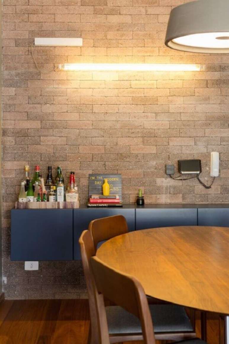 44. Parede de tijolinho para decoração de sala de jantar com buffet azul e mesa de madeira – Foto: Design Milk