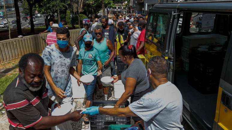 Pessoas em situação de rua recebem marmitas nas ruas de São Paulo. Março de 2021